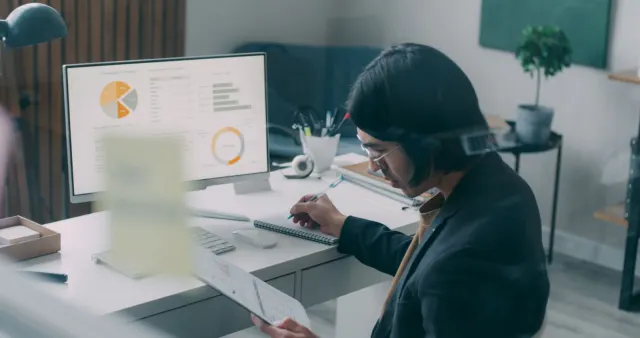 Analyst reviewing charts and performance data on a monitor